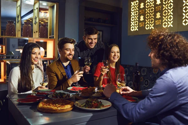 Amigos hablan divertido en la mesa en el restaurante — Foto de Stock