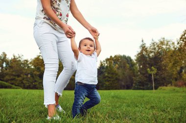 Çocuk ile anne parkta yaz aylarında yürür.. 