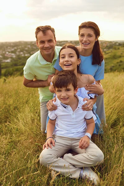Портрет щасливої сім'ї, що сидить на природі в траві . — стокове фото