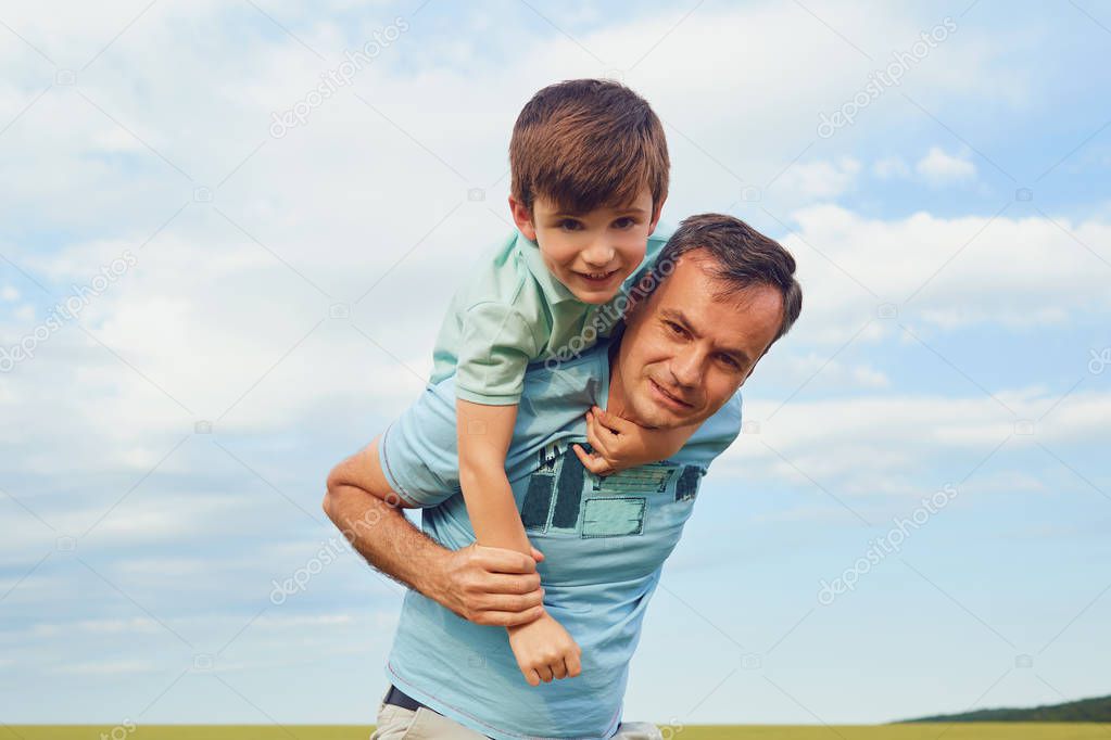Father and son are playing in the field. 