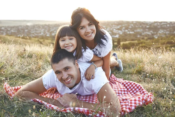 Familie lächelnd auf dem Gras in der Natur liegend. — Stockfoto