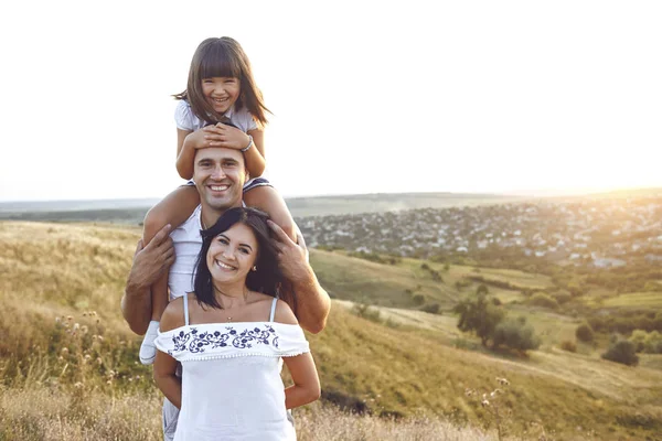 Een vrolijke familie lacht in de zonsondergang. — Stockfoto