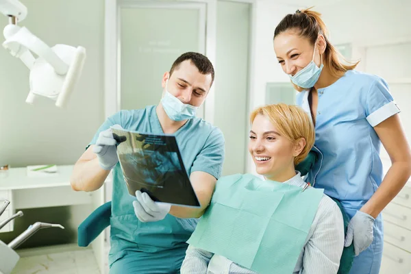 Dentiste avec un patient regarder l'image radiographique — Photo