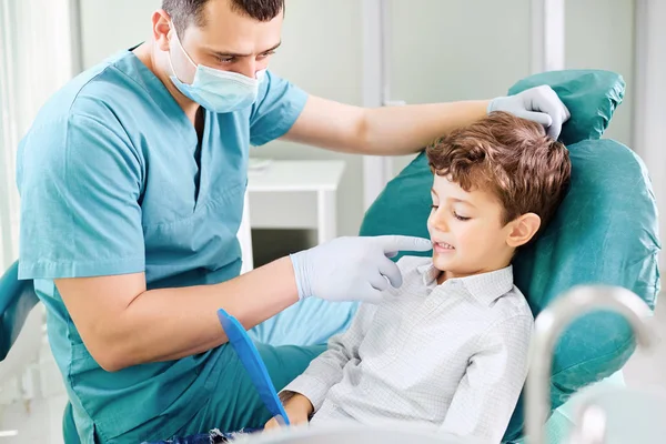 Kind und Zahnarzt prüfen Zähne im Spiegel. — Stockfoto