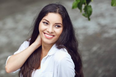 Açık havada gülümseyen güzel mutlu esmer kadın. 