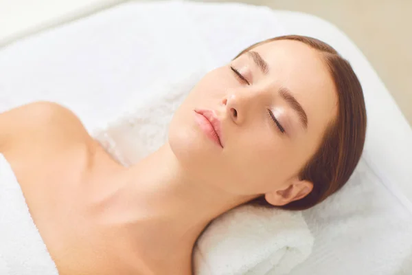 Skönhets-och Spa-konceptet. Brunett flicka som ligger på en massage skriv bord — Stockfoto