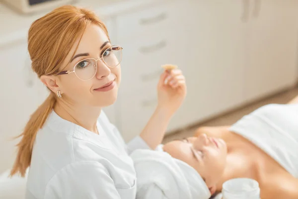 La esteticista sonríe en la sala de cosmetología . —  Fotos de Stock