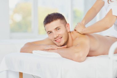 Genç adam yatıyor üzerinde masa ile gözler kapalı zevk Masaj