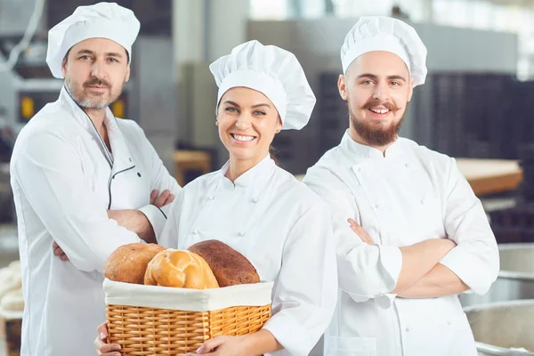 Un gruppo di panettieri sorride al panificio — Foto Stock