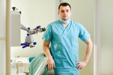 Bir erkek dişçi mikroskop ile ayakta