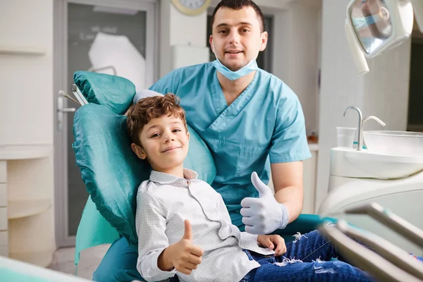 Glücklicher Zahnarzt und Kind hoben den Daumen — Stockfoto