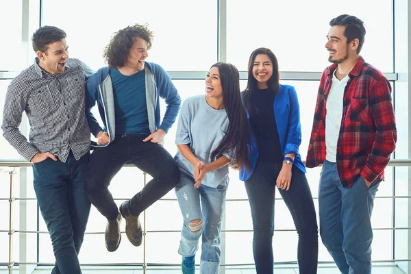 Young people stand against the window — Stock Photo, Image