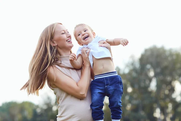 Mãe com uma criança brinca no parque . — Fotografia de Stock