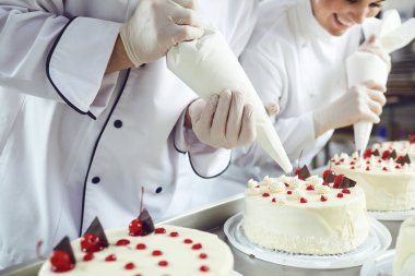İki pasta şefleri bir pasta dükkanında bir çanta bir kek süslemeleri