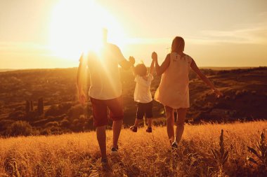Gün batımında doğada aile ayakta arkadan görünüş