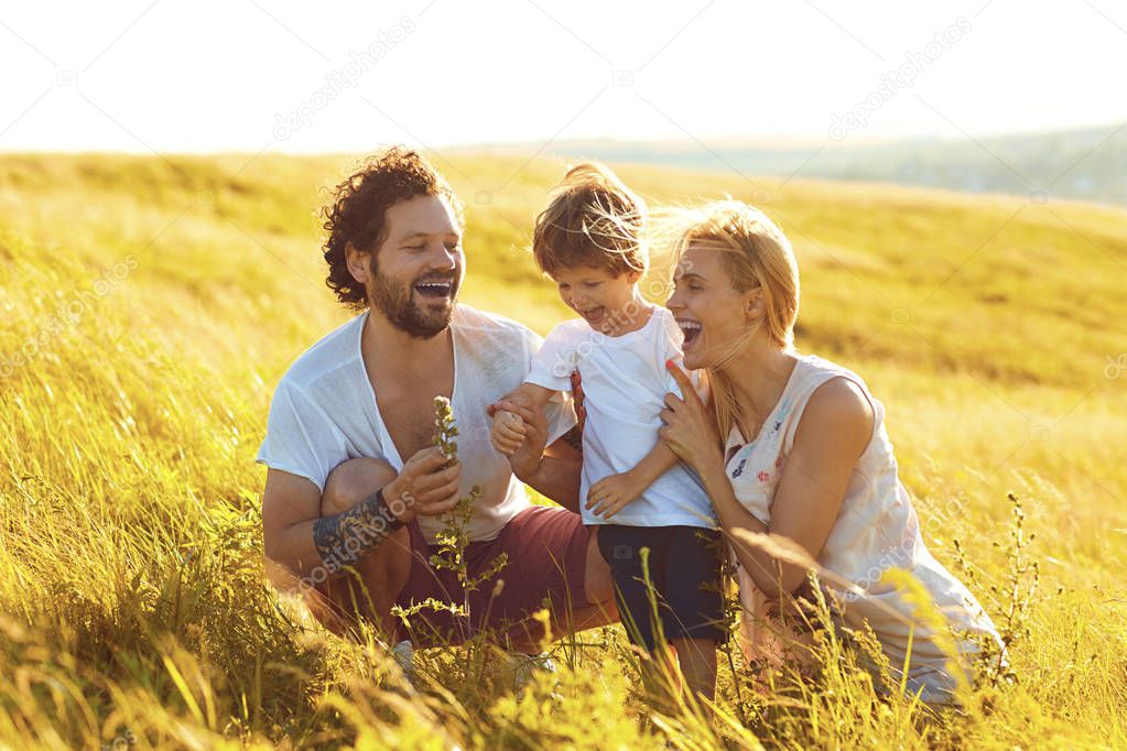 Happy family having fun playing  in the field.