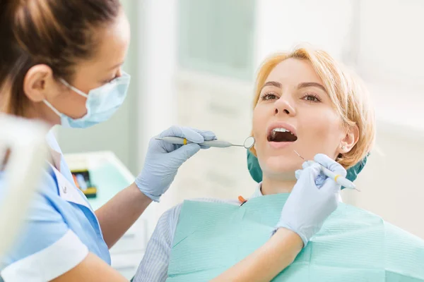 Kobieta dentysta sprawdza zęby dziewczyny — Zdjęcie stockowe