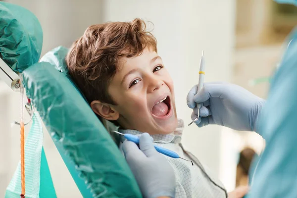 Child smiling while sitting in the dentists chair.