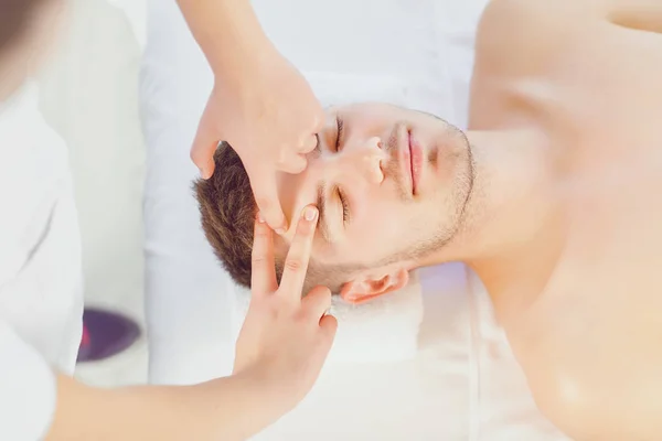 Mulher massageando rosto do homem — Fotografia de Stock