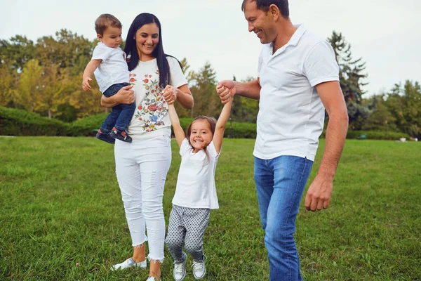 Çim parkta oynarken çocuklu aile. — Stok fotoğraf