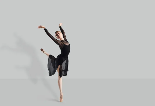 Female ballet dancer dancer over gray background. — Stock Photo, Image