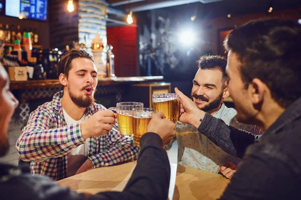 Vrienden praten, biertje drinken in een bar. — Stockfoto