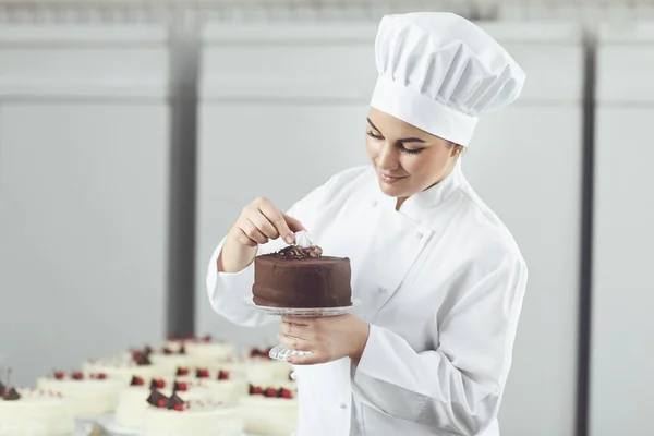 Confeiteiro decoração bolo de chocolate na pastelaria . — Fotografia de Stock