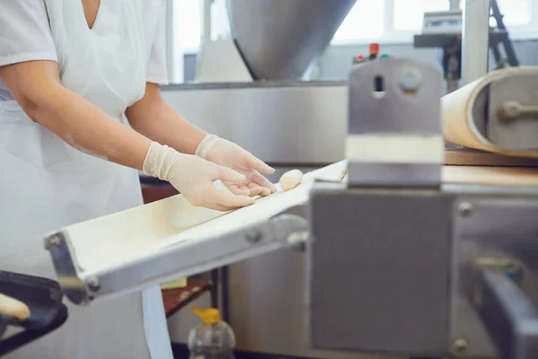 Las manos de una mujer que trabaja en el equipo hacen que la masa para el pan — Foto de Stock