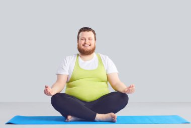 Pozitif şişman adam Yogi yoga egzersizleri gri bir arka plan yok.