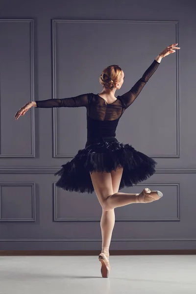 Μπαλαρίνα χορεύτρια με μαύρο φόρεμα που ποζάρει πάνω από γκρι φόντο. — Φωτογραφία Αρχείου