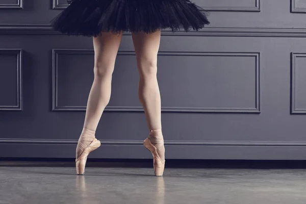 Las piernas de una bailarina sobre un fondo negro . — Foto de Stock