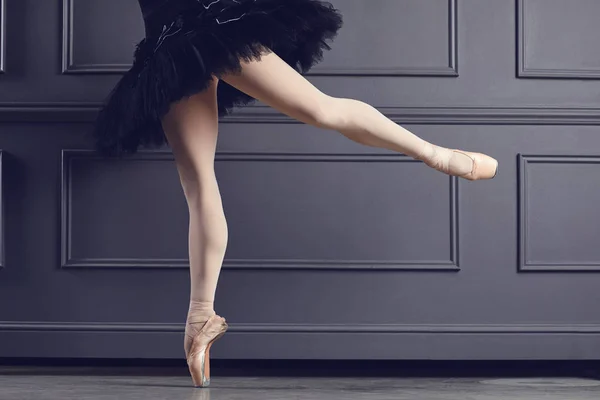 Beine einer Ballerina auf schwarzem Hintergrund. — Stockfoto