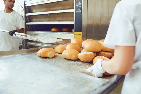 Les boulangers sortent le pain du four dans la boulangerie . — Photo