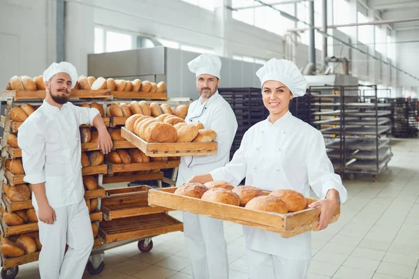 I panettieri tengono un vassoio con pane fresco nel panificio . — Foto Stock