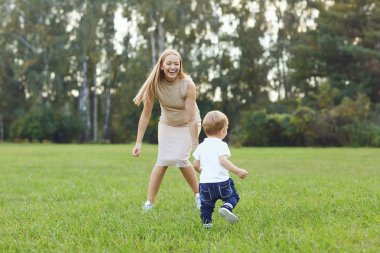 Bir çocuk ile anne parkta oynuyor.