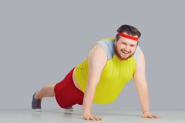 Dikke grappige kerel met een baard doen push-up gaat voor sport. — Stockfoto