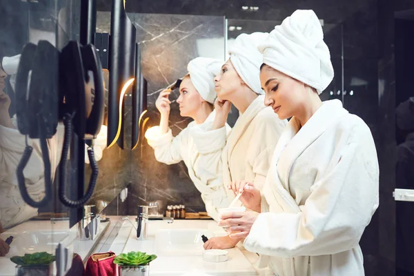 Um grupo de mulheres make-up na frente do espelho fazer — Fotografia de Stock