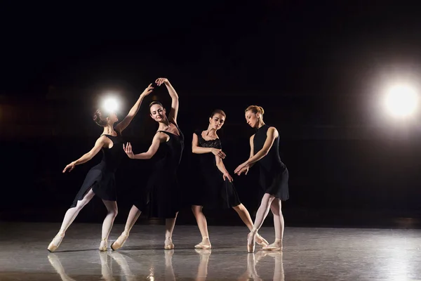 Un groupe de ballerines dansent sur la scène sur fond noir . — Photo