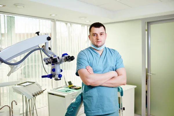 A male dentist is standing with a microscope Royalty Free Stock Photos