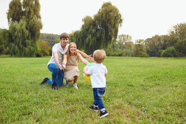 Glückliche Familie spielt auf dem Rasen im Park. — Stockfoto