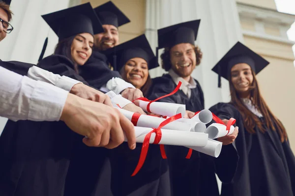 Schriftrollen in den Händen der Absolventen. — Stockfoto