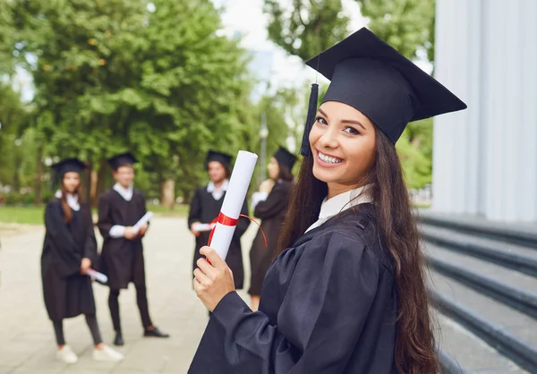 Una joven graduada en el contexto de los graduados universitarios . — Foto de Stock