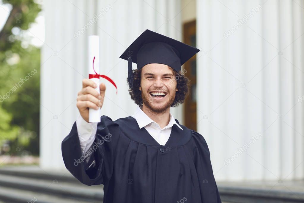 A young man graduate is smiling on university graduates.