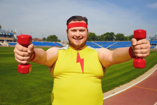 Hombre gordo con mancuernas deportes en el estadio . — Foto de Stock