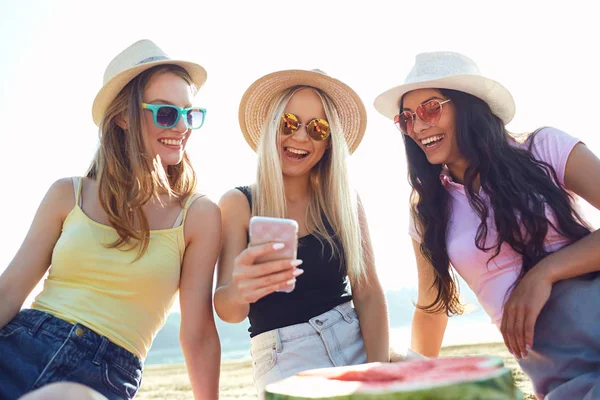 Amigos en una fiesta hacen selfie en el teléfono en la playa . —  Fotos de Stock