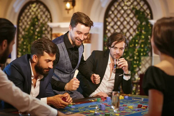 En ung man är glad att vinna på kasinot. — Stockfoto