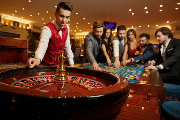 De croupier houdt een roulette bal in een casino in zijn hand. — Stockfoto