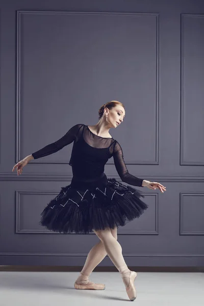 Ballerine dans un tutu noir posant sur un fond noir . — Photo