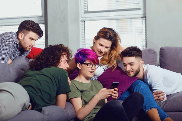 Een groep vrienden op een bijeenkomst die samen praten op de kamer. — Stockfoto