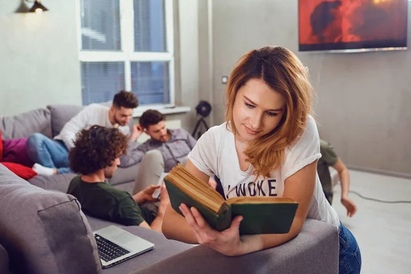 Une étudiante lit un livre sur fond d'amis . — Photo